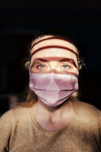 Woman wearing a surgical mask during quarantine in her house