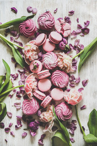 Sweet pink macarons  marshmallows and spring flowers on wooden background
