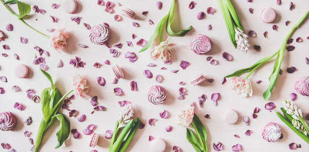 Flat lay of macaron cookies  marshmallows and flowers over pink background