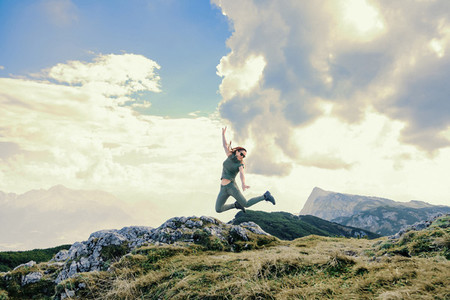 Young woman jumping in a mountain
