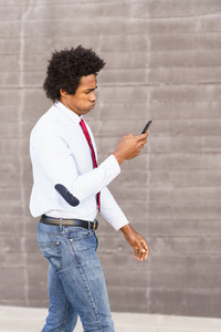 Concerned Black Businessman using his smartphone outdoors
