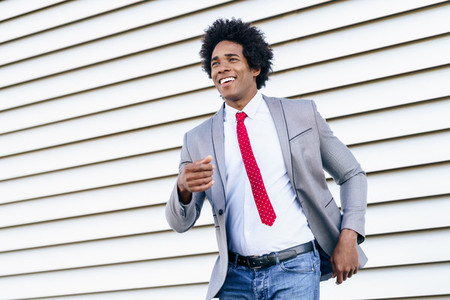 Happy Black Businessman wearing suit dancing outdoors