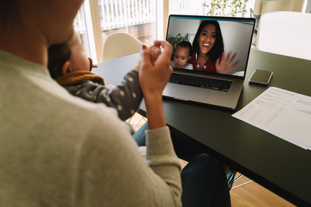 Women with their kids having a video call on laptop