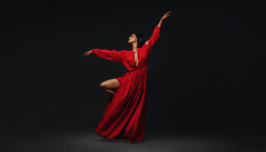 Woman dancing gracefully on black background