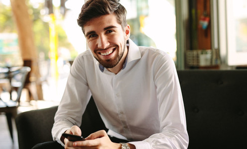Smiling businessman at coffee shop in morning