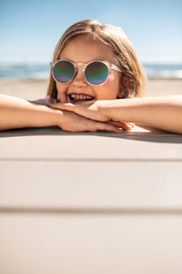 Beautiful girl leaning over a beach boardwalk