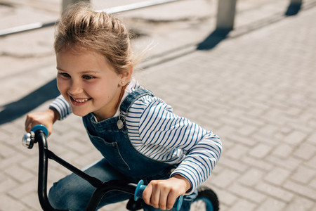 Small girl enjoying riding her bike outdoors