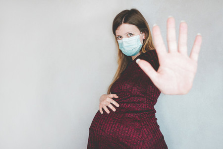 Young pregnant woman wearing a face mask