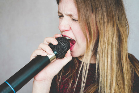Young woman singing with a microphone
