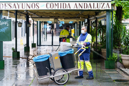 GRANADA  SPAIN  23RD APRIL  2020 Sweepers cleaning the streets with coronavirus protection masks