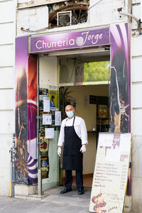 GRANADA  SPAIN  23RD APRIL  2020 Cooking a churro shop standing in the doorway of his shop  wearing a mask