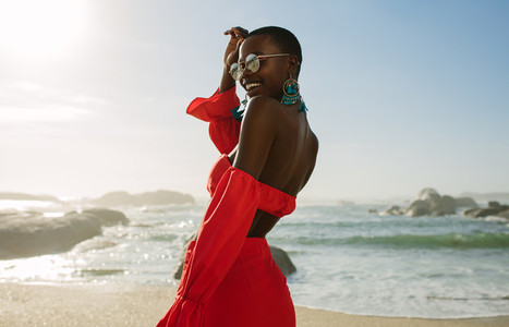 Beautiful african woman in red dress enjoying on the beach