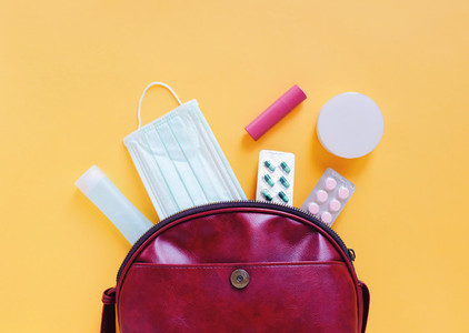 Flat lay of red leather woman bag open out with cosmetics  acces