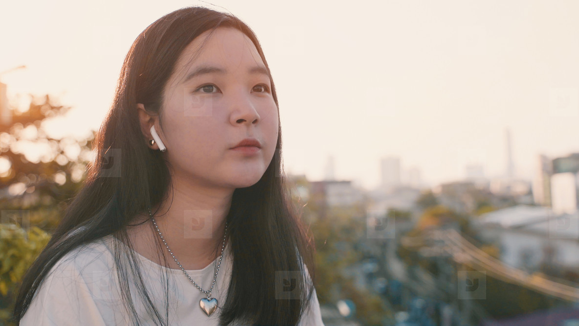 Young asian millennial gen z woman standing at rooftop feeling b