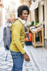 Black man with wireless headphones sightseeing in Granada