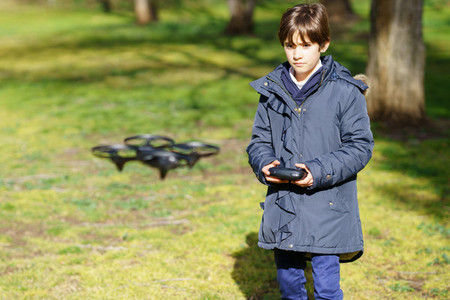 Nine year old girl operating toy drone flying by remote control