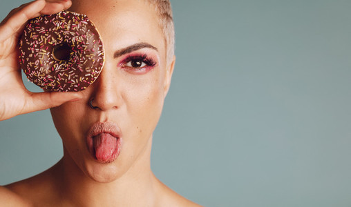 Woman with a donut sticking out her tongue