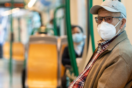 Senior man wearing surgical mask in the train during the Covid 19 pandemic