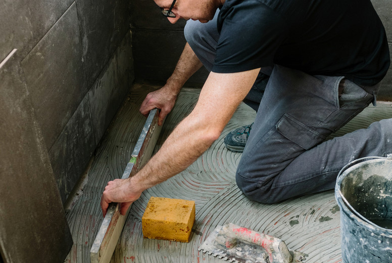 Bricklayer checking floor with a level