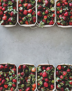 Fresh strawberries in plastic free boxes over concrete background  copy space