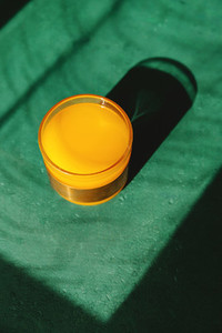 Summer creative photography with sunlight and shadows of orange juice