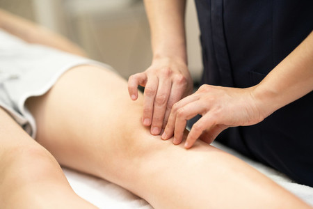Physiotherapist woman doing a treatment on a womans knee