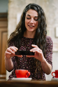 Young woman with some gray hair using smartphone in a cafe