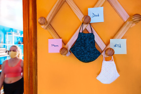 Surgical masks of family hanging on the coat rack with labels