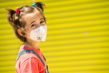 Child girl wearing a protection mask against coronavirus during Covid 19 pandemic