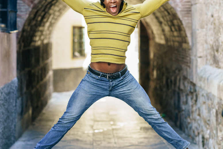 Black man with afro hair jumping for joy