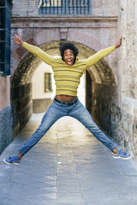 Black man with afro hair jumping for joy