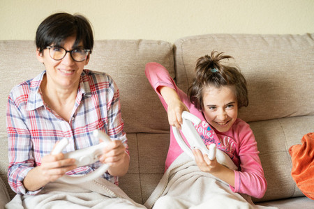Mother and daughter playing video games at home