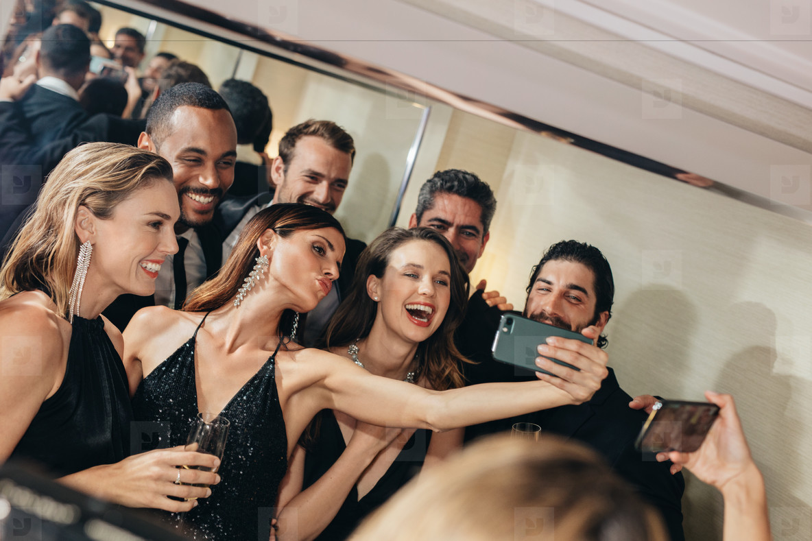 Attractive woman with friends taking selfie at a gala event