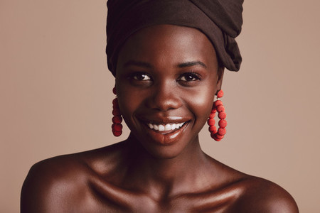 Beautiful african woman with turban against beige background