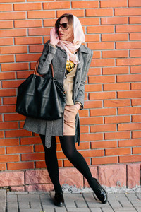 girl posing on a background of red brick wall