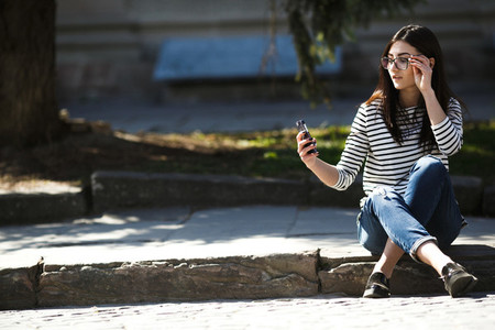model in the middle of the city with phone