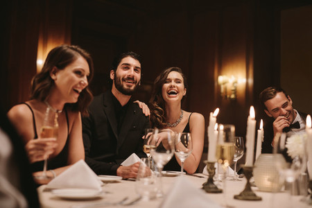 Socialites sitting around a dining table at a party