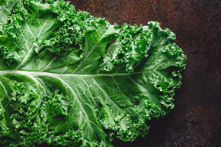 Fresh curly kale salad over dark rustic background  Top view  healthy eating background