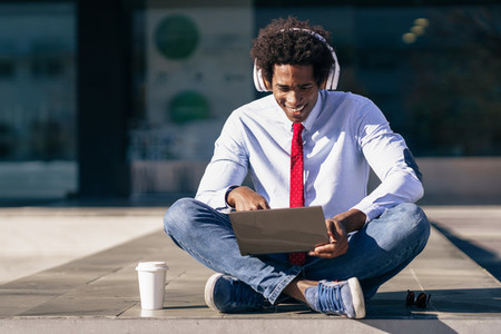 Black Businessman using laptop computer and headphones