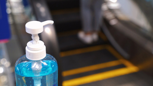Close up alcohol gel sanitizer at the escalator for prevent the
