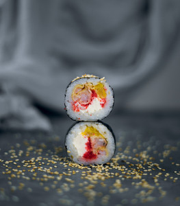 two sushi with sesame on a gray background