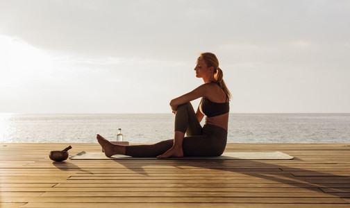 Woman practicing yoga near the sea
