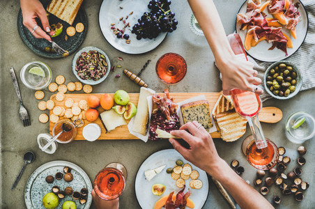 Summer picnic with wine and snacks and peoples hands