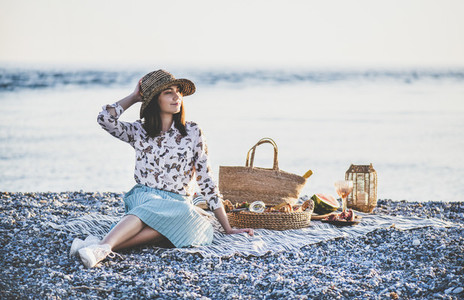 Young smiling woman having weekend picnic at seaside