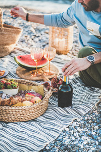 Couple having picnic with bottle of sparlking wine and snacks