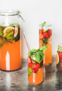 Fresh homemade lemonade or iced tea with strawberry and basil leaves