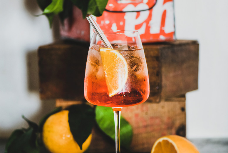 Aperol Spritz cocktail in glass with eco-friendly straw on board