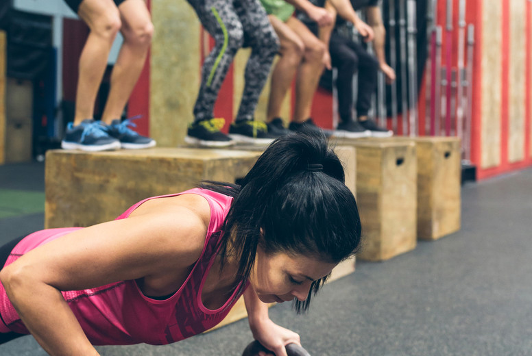 Sportswoman doing push-ups with kettlebells