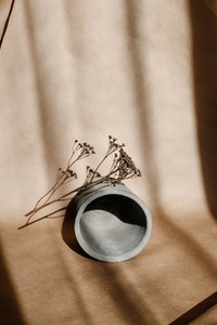 Abstract creative minimal composition with a clay pot and dry grass against kraft paper  Natural and ecological products concept