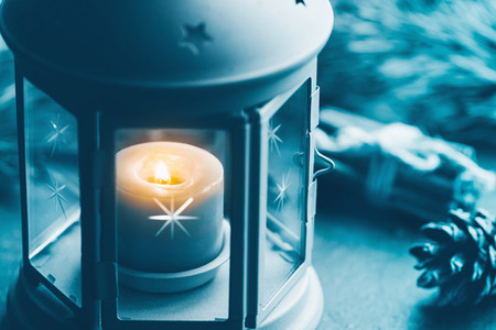 Close up photo of a blue vintage lantern with burning candle among Christmas decoration  Concept of New Year and wintertime
